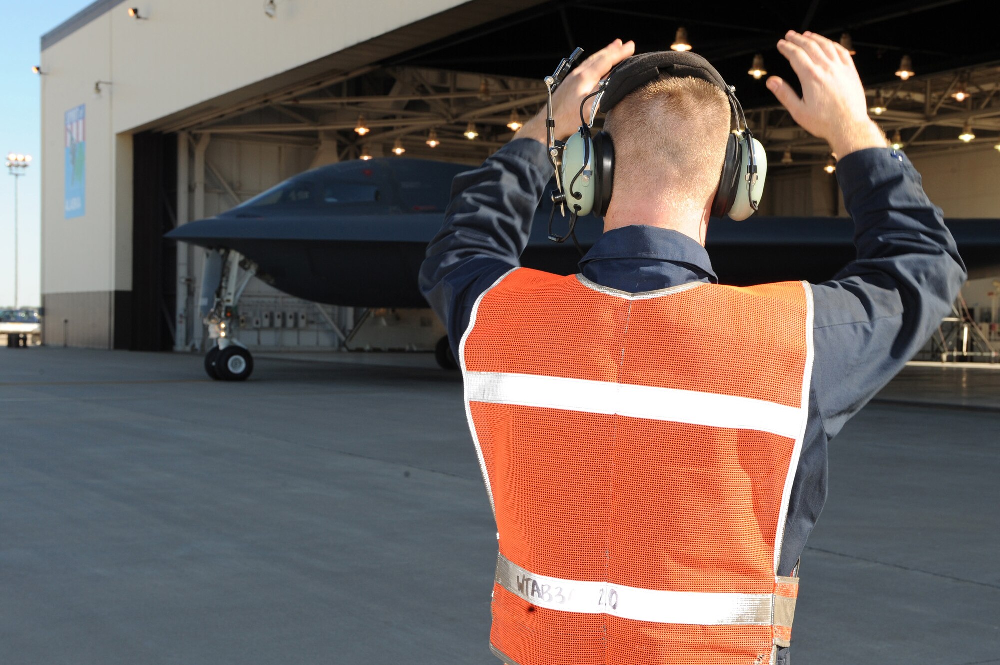 WHITEMAN AIR FORCE BASE, Mo.- Senior Airman Mark Decumen, 509 Aircraft Maintenance Squadron crew chief, waves out a B-2 Spirit for taxi out of the hanger during the "Beast Walk,"as part of the Nuclear Operation Readiness Exercise, Sept. 29. The NORE is in preparation of the Nuclear Operational Readiness Inspection Oct 11. (U.S. Air Force photo/Airman 1st Class Carlin Leslie)