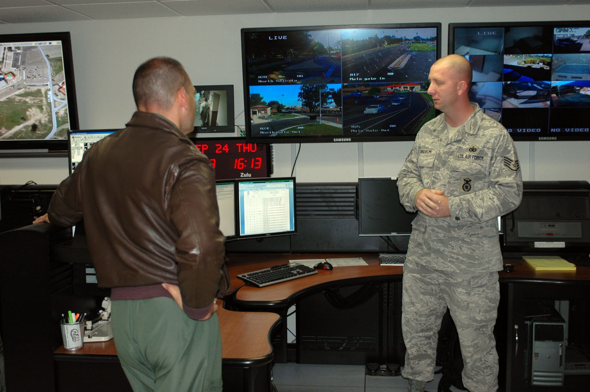 Staff Sgt. Joseph Guglielmi, (right), 60th Security Forces Squadron, speaks to Col. Jim Vechery, 60th Air Mobility Wing commander, about the new Consolidated Emergency Dispatch Center here at Travis. The center, that opened earlier this month, enables emergency personnel to expedite response time and service to an emergency by co-locating fire, police and medical personnel in one location. (U.S. Air Force photo/Senior Airman Kristen Rohrer)