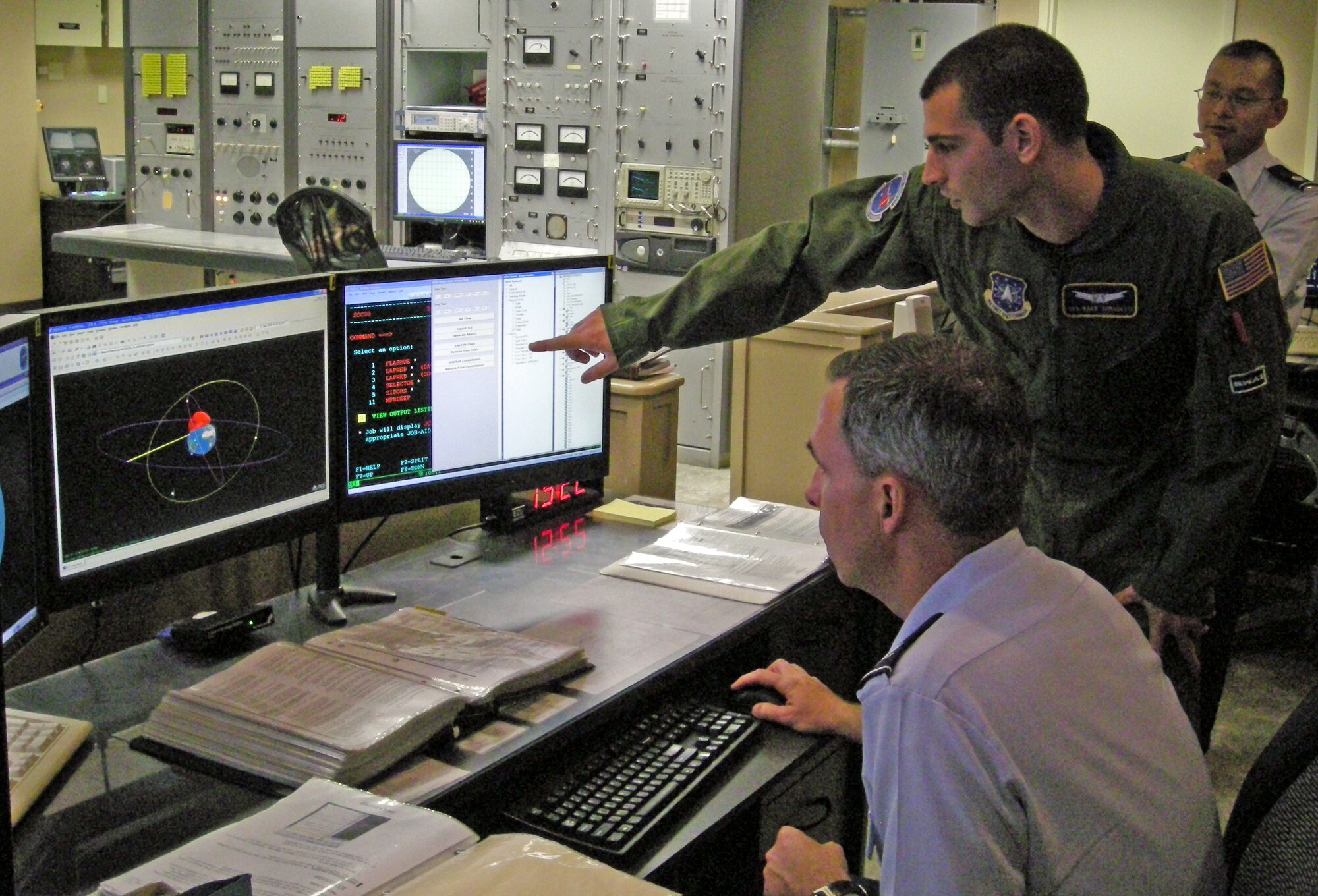Senior Airman Mark Tomasetti, 20th Space Control Squadron, displays the 20th SPCS's advanced Satellite Tool Kit (STK) to Col. Stephen Whiting, 21st Space Wing commander. The STK software provides a three dimensional representation of a satellite's location to aid in tracking high-interest objects, a crucial element of providing America with flawless missile warning and space control operations. (Air Force photo by 1st Lt. Joshua McCullion)