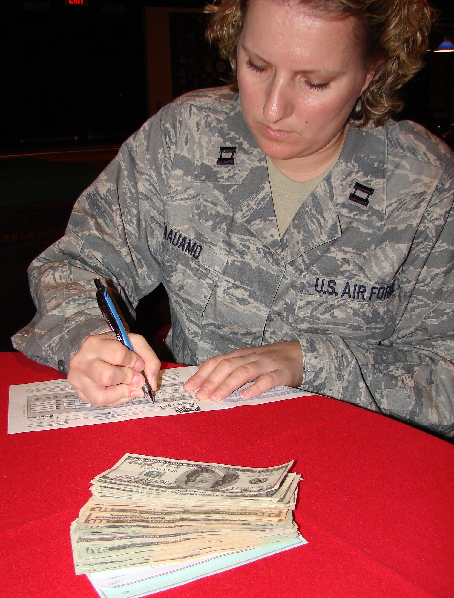Capt. Jamie Kaauamo, president of the Vance Company Grade Officer’s Council, completes a Combined Federal Campaign contribution form to donate $750 to the “Friends of Vance Families,” a local CFC organization. The CGOC raised the money during a recent crud tournament at the Vance Collocated Club and donated it during the Vance 2009 CFC kick off held Sept. 25 during lunch at the Club. (U.S. Air Force photo/ Joe B. Wiles)
