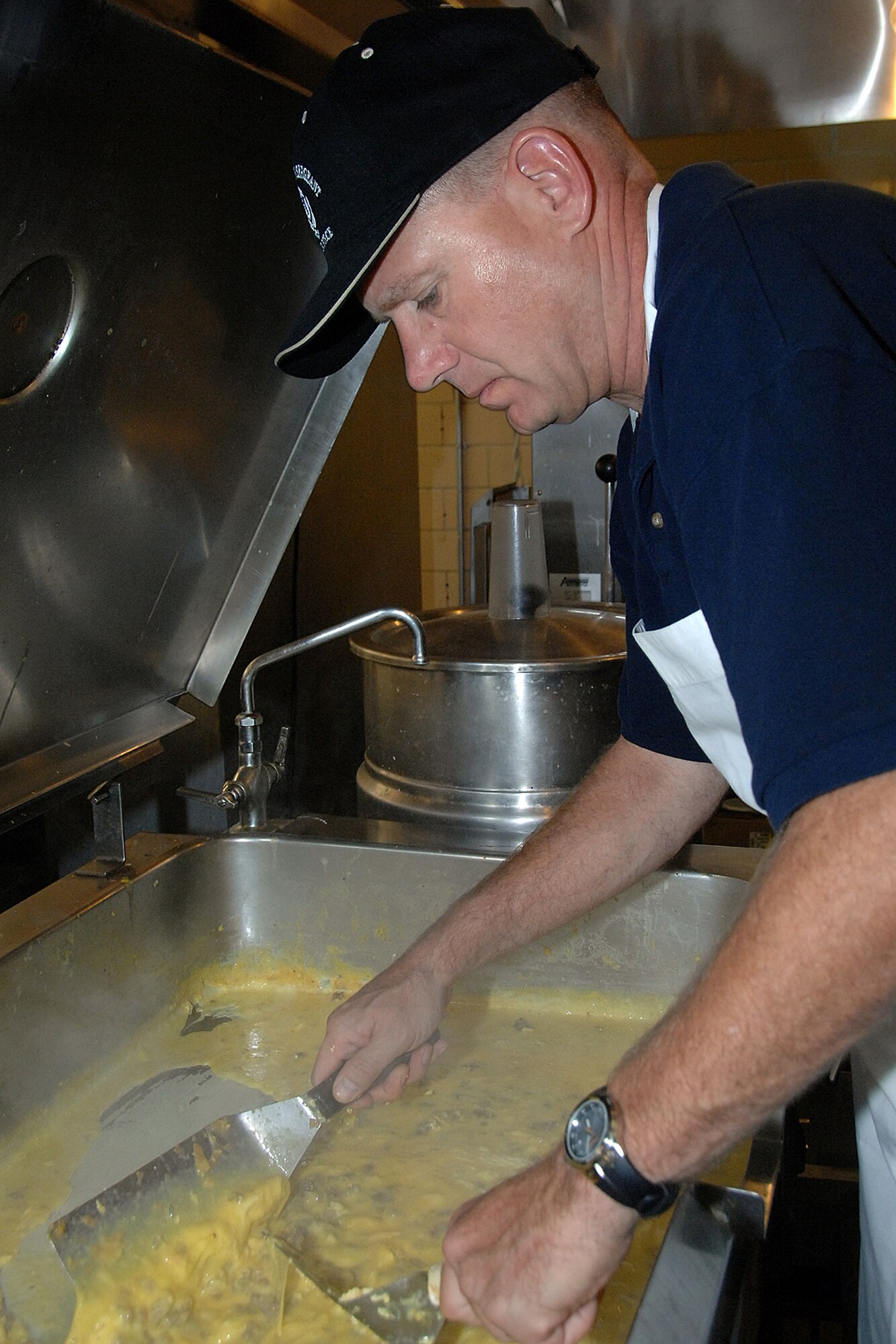 OFFUTT AIR FORCE BASE, Neb. - Chief Master Sgt. Joseph Kost, a 55th Wing Inspector General member, scrambles eggs with sausage during the Chief's Pancake Feed Sept. 23 at the Patriot Club. Offutt?s chief master sergeants prepared all-you-can-eat meals of sausage, eggs, fruit and pancakes as part of their annual fundraiser. U.S. Air Force photo by Kendra Williams.