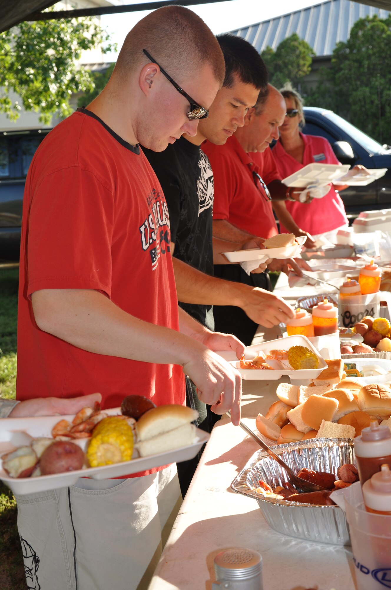 Airmen 1st Class Adam Huey, 96th Medical Support Squadron and Neil Johnson, 96th Communications Squadron go through the line during a dorm resident shrimp boil sponsored by the Niceville-Valparaiso Chamber of Commerce Military Affairs Committee Sept. 25 here.  More than 150 Airmen took part in the event aimed at showing appreciation to Eglin’s most junior members.(Air Force photo/ Staff Sgt. Bryan Franks)