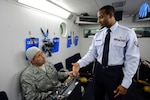 Chief Master Sgt. Max Grindstaff, 12th Flying Training Wing command chief from Randolph Air Force Base, Texas listens as Senior Airman Ivan Wilson, an aerospace physiology technician with the 12th Medical Group goes through the operational procedures of an oxygen regulator inside the bases high altitude chamber. (U.S. Air Force photo/Steve Thurow)