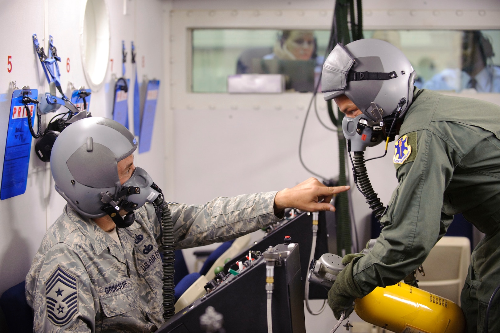 Chief Master Sgt. Max Grindstaff 12th Flying Training Wing command chief from Randolph Air Force Base, Texas questions Tech. Sgt. Mike Stegen, an aerospace physiology technician with the 12th Medical Group  about the equipment used for delivering oxygen during training in the bases high altitude chamber. (U.S. Air Force photo/Steve Thurow)