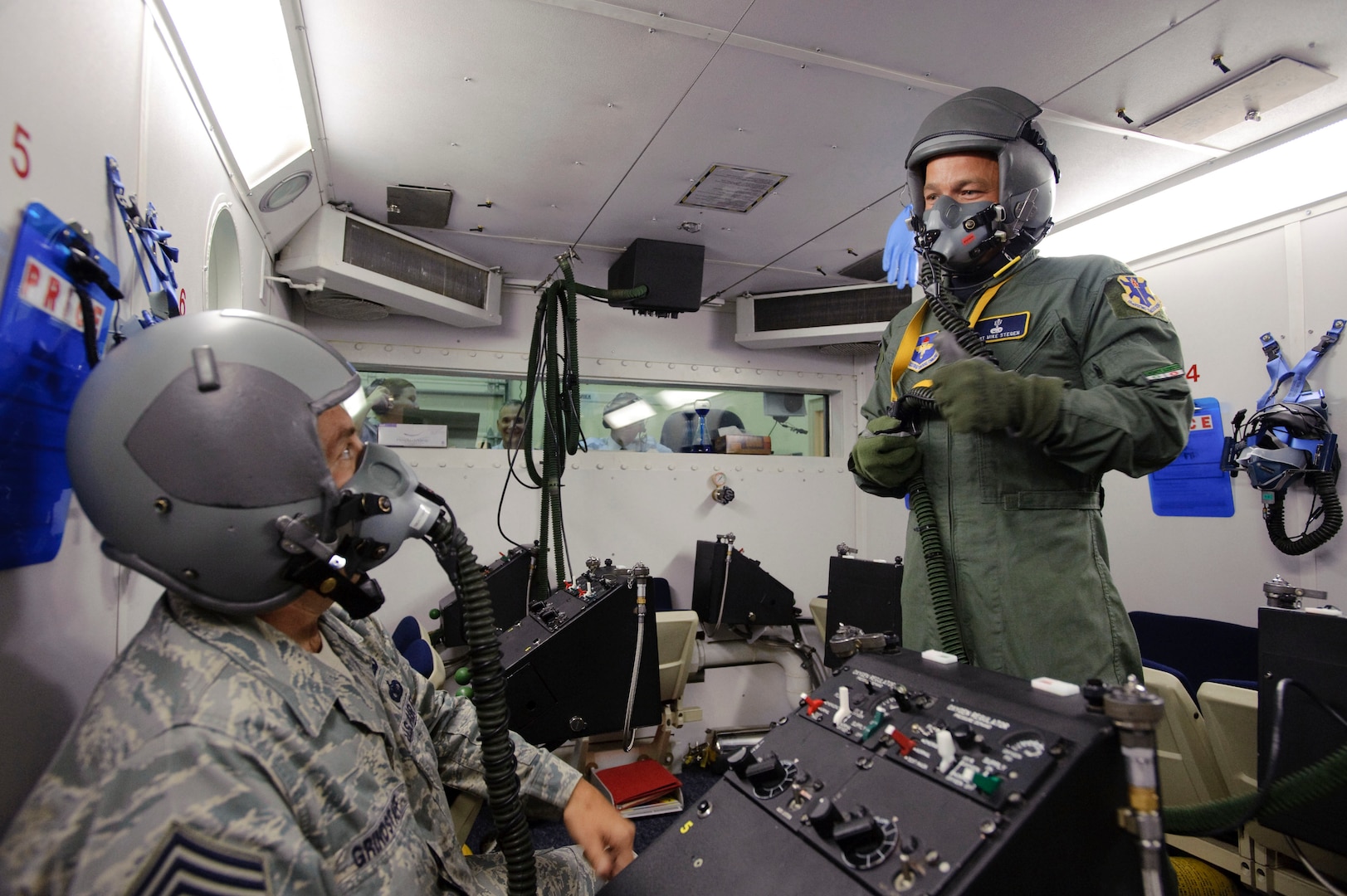 Tech. Sgt. Mike Stegen, an aerospace physiology technician with the 12th Medical Group (right) signals Chief Master Sgt. Max Grindstaff 12th Flying Training Wing command chief from Randolph Air Force Base, Texas, with a 'thumbs up,' to confirm that all equipment is operational before taking the bases high altitude chamber to 25,000 feet. (U.S. Air Force photo/Steve Thurow)