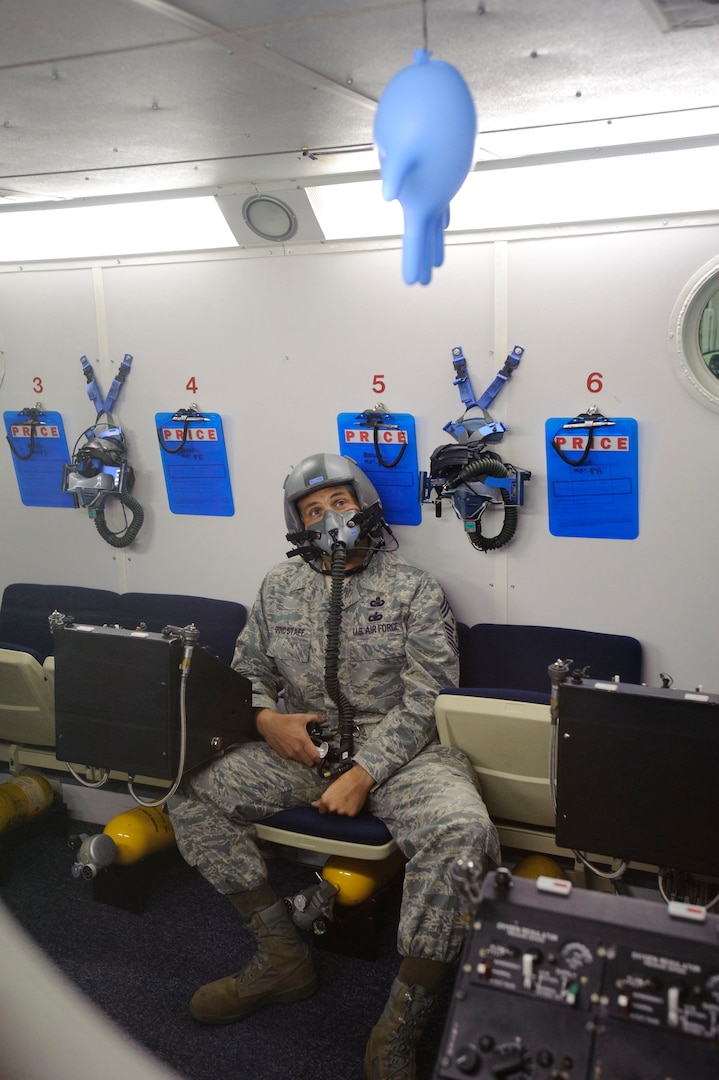 Chief Master Sgt. Max Grindstaff, 12th Flying Training Wing command chief from Randolph Air Force Base, Texas watches the effects of decreased atmospheric pressure on gases trapped inside the sinuses or middle ear, which expand 3x at an unpressurized altitude of 25,000 feet during a training mission in the 12th Medical Group's high altitude chamber. (U.S. Air Force photo/Steve Thurow)
