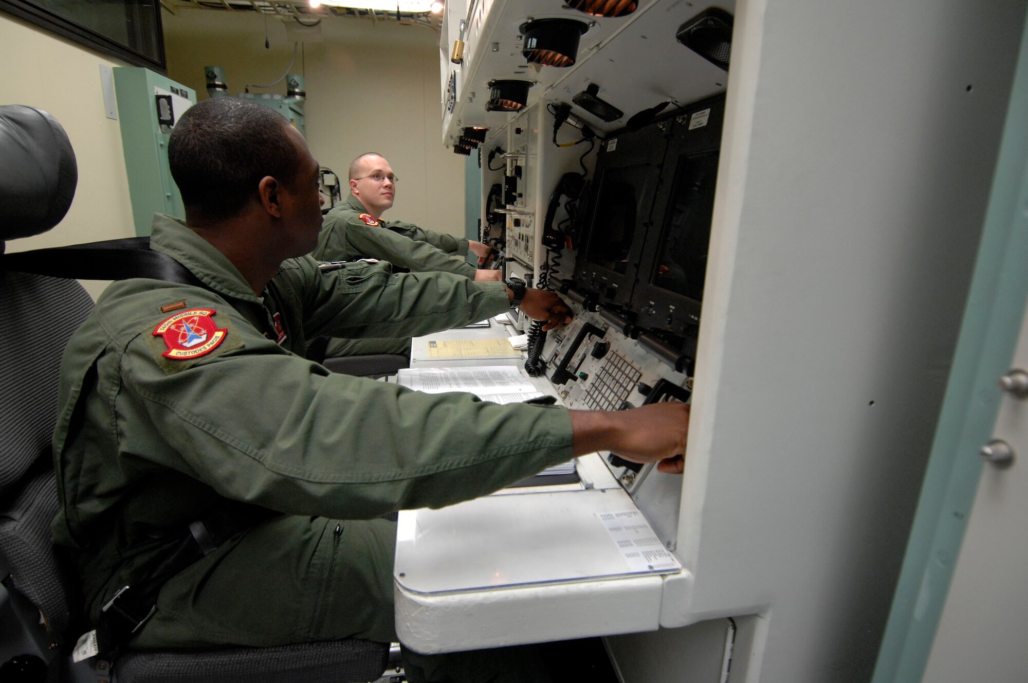 MINOT AIR FORCE BASE, N.D. -- 2nd Lt. Glen Jasper (near) and 1st Lt. Jeremy King (far), both from the 740th Missile Squadron, simulate launching a Minuteman III intercontinental ballistic missile at the missile procedure trainer here Sept. 24. Lieutenants King and Jasper performed the simulation as part of an 91st Missile Wing operations competition. (U.S. Air Force photo by Senior Airman Matthew Smith)  