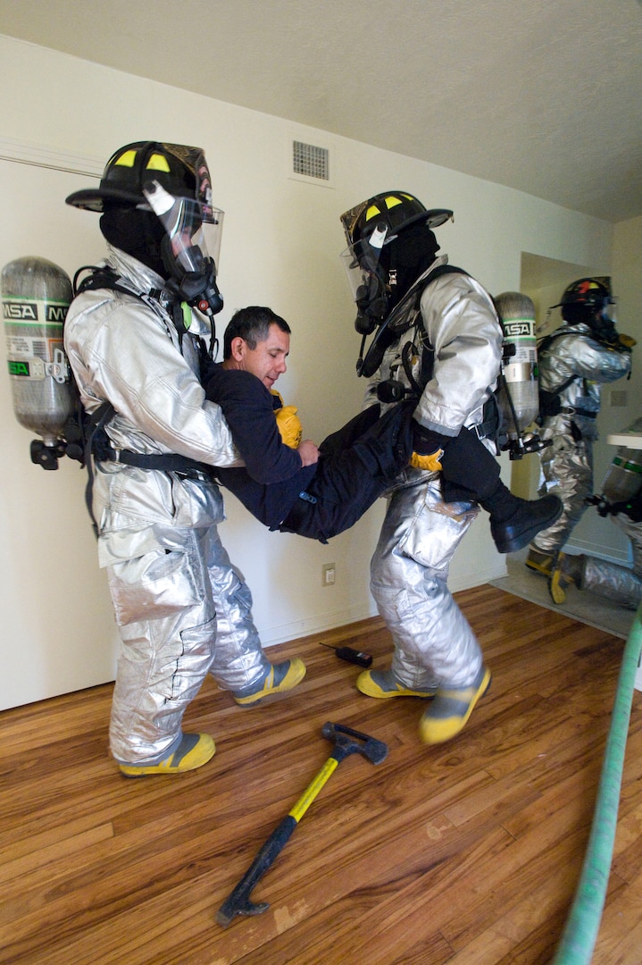 Firefighters with the Fire and Emergency Services 12th Civil Engineer Division, Randolph Air Force Base, Texas remove a simulated victim of a housing unit with a simulated kitchen fire during a training exercise conducted on Sept. 29. (U.S. Air Force photo/Steve Thurow) 