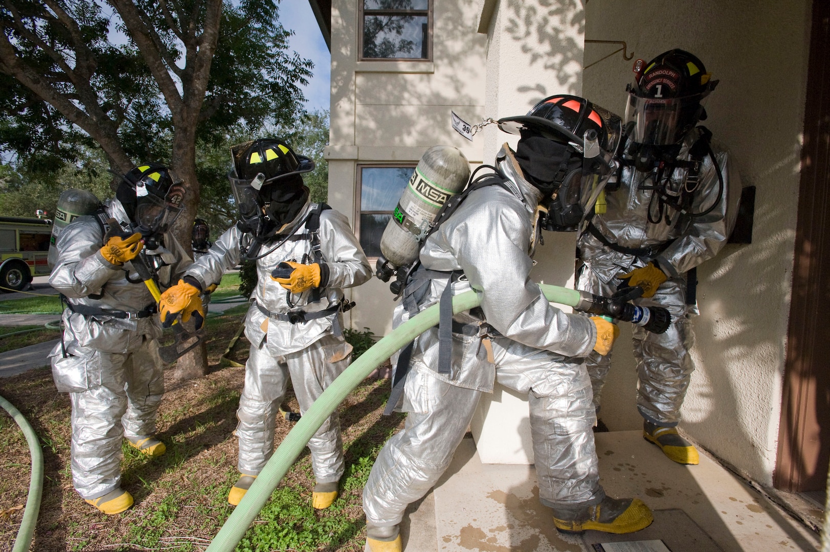 Firefighters with the Fire and Emergency Services 12th Civil Engineer Division, Randolph Air Force Base, Texas enter a housing unit with a simulated kitchen fire to search for possible victims during a training exercise conducted Sept. 29. (U.S. Air Force photo/Steve Thurow) 