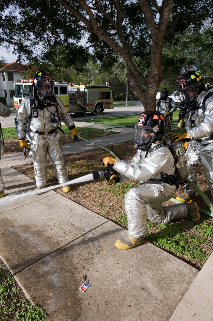 Firefighters with the Fire and Emergency Services 12th Civil Engineer Division, Randolph Air Force Base, Texas function check their equipment prior to entering a housing unit with a simulated kitchen fire to search for possible victims during a training exercise conducted on Sept. 29. (U.S. Air Force photo/Steve Thurow) 