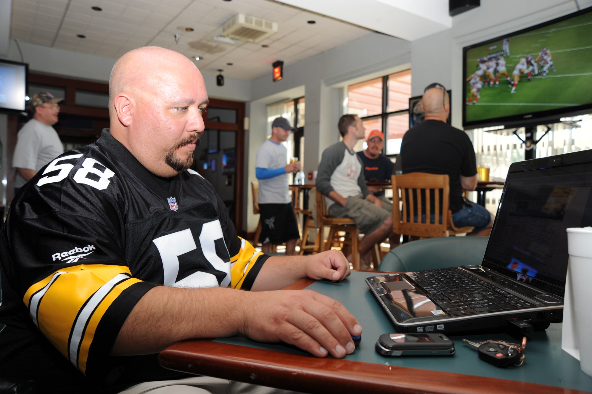 Steve Tiger, a facility maintainer from the 22nd Medical Group, checks statistics online during Football Frenzy at the McConnell Air Force Base, Kan., Storm Cellar club and sports bar, Sept. 27, 2009. Sports fans watched pro-football games on the club’s seven televisions. The club sells food and beverages and offers customers free internet access. The 22nd Force Support Squadron hosts Football Frenzy here every Sunday, Monday and Thursday throughout the season. (U.S. Air Force photo/Tech. Sgt. Chyrece Campbell)