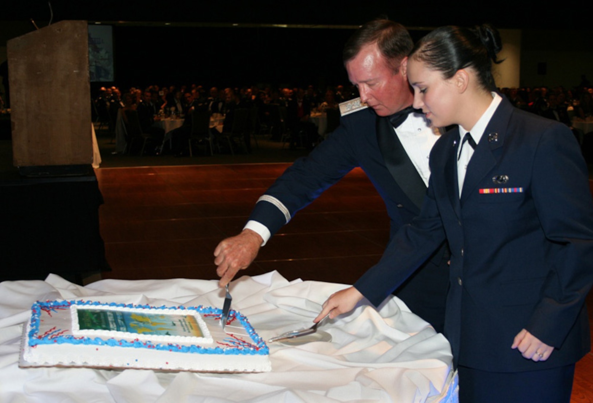 ANCHORAGE, Alaska -- The 3rd Wing celebrated 90 years of airpower during the Air Force Ball here Sept. 26. Lt. Gen. Dana Atkins, 11th Air Force commander, and Airman Basic Jessica Roybal, 3rd Contracting Squadron, served up the first slice of cake to mark the event. They were selected to cut the cake for being the highest and lowest ranking Airmen on Elmendorf. The ball also marked the Air Force's 62nd birthday. (U.S. Air Force photo/Tech. Sgt. Jason Rosenbaum)