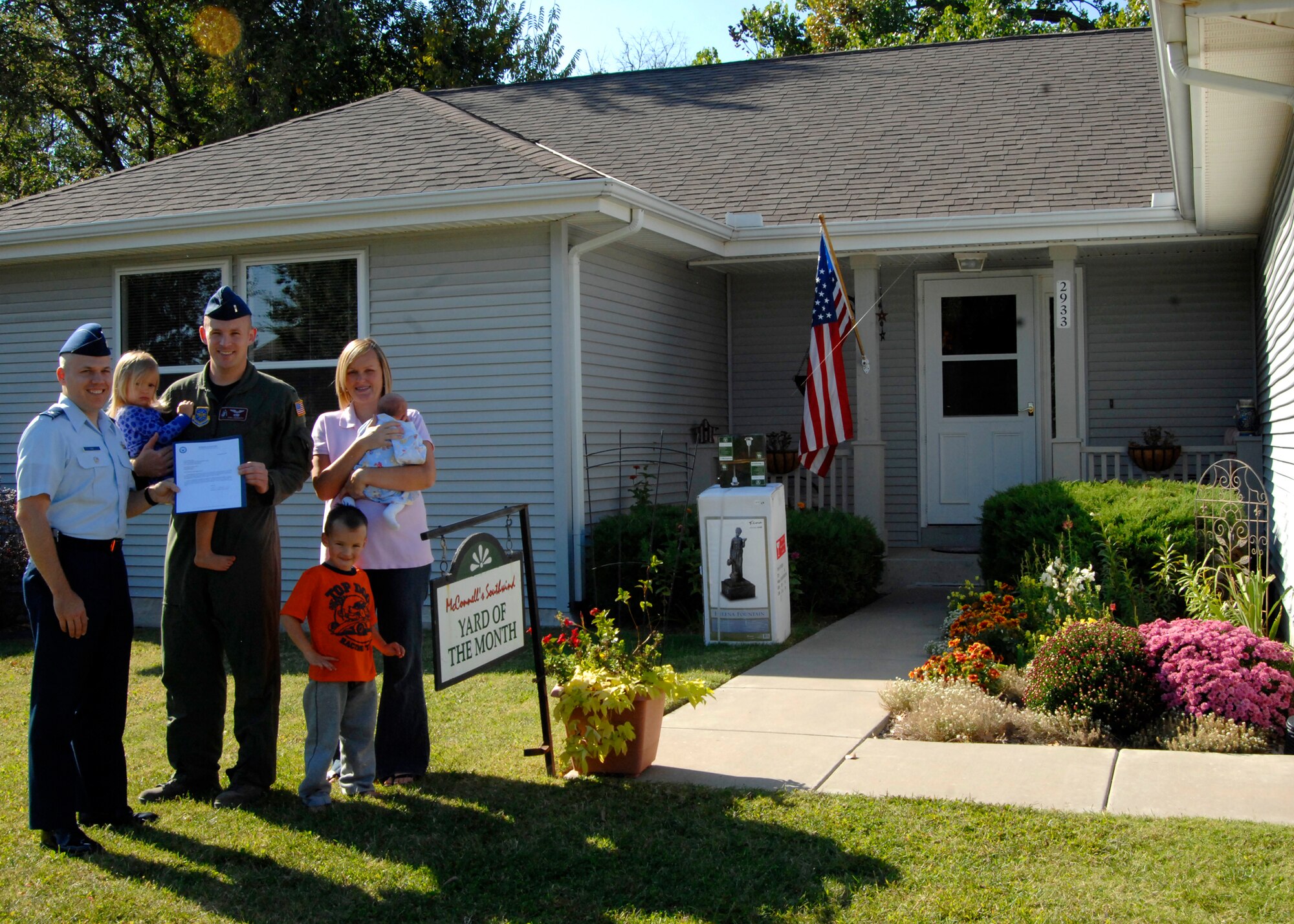 Lt. Col. Roman Hund, 22nd Mission Support Group deputy commander, recognizes 1st Lt. John Langworthy, 384th Air Refueling Squadron, spouse, Ellen and children, J.J, 4, Maddie, 2, and Zach, two-weeks-old, at their home for winning Southwind Housing Yard of the Month at McConnell Air Force Base, Kan., for September. The annual competition runs from May to September. (U.S. Air Force photo/Senior Airman Laura Suttles)