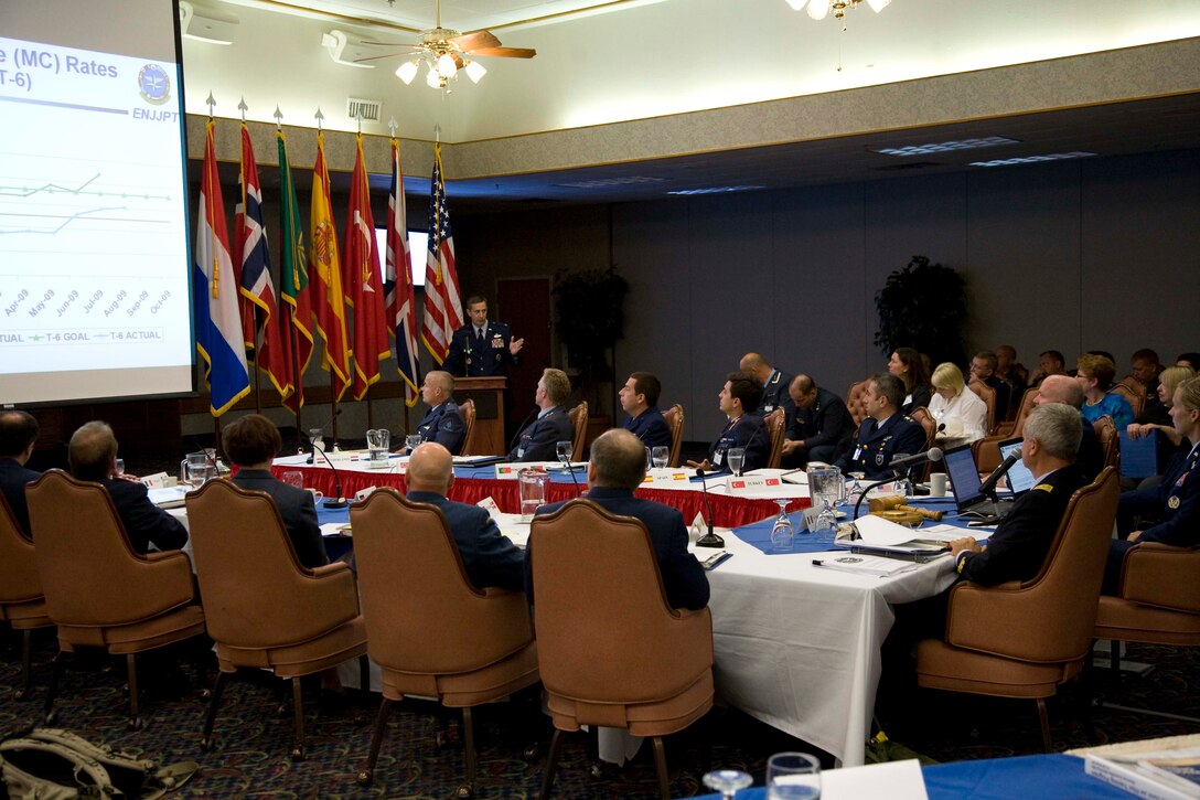 Col. Kevin Schneider, 80th Flying Wing commander, provides a wing update briefing to the attendees of the Euro-NATO Joint Jet Pilot Training Program’s Steering Committee No. 58. The members discussed the flow of student pilots, instructor pilot training, leadership and command opportunities, maintenance statistics and plans for ENJJPT. (U.S. Air Force photo/ Lt. Col. Ternell Washington)     
