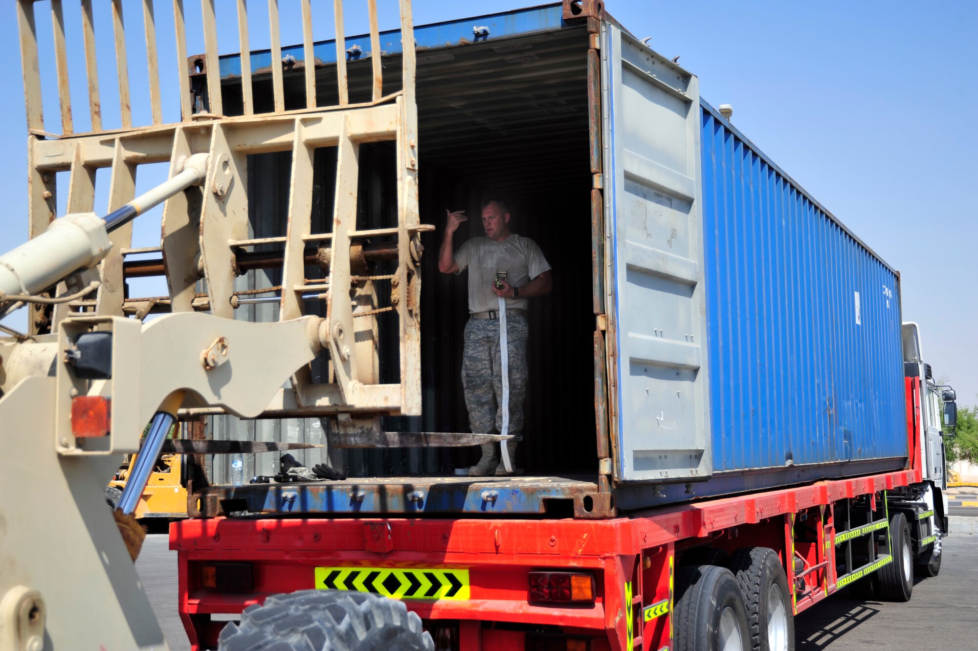 SOUTHWEST ASIA -Staff Sgt. LaWayne Rogers, 380th Expeditionary Logistics Readiness Squadron, marshals the driver of a forklift forward to remove a shipping pallet from a trailer here Sept. 29, 2009. Sergeant Rogers is deployed from the 132nd Fighter Wing, Iowa Air National Guard, and grew up in Altoona, Iowa. (U.S. Air Force photo/Tech. Sgt. Charles Larkin Sr)