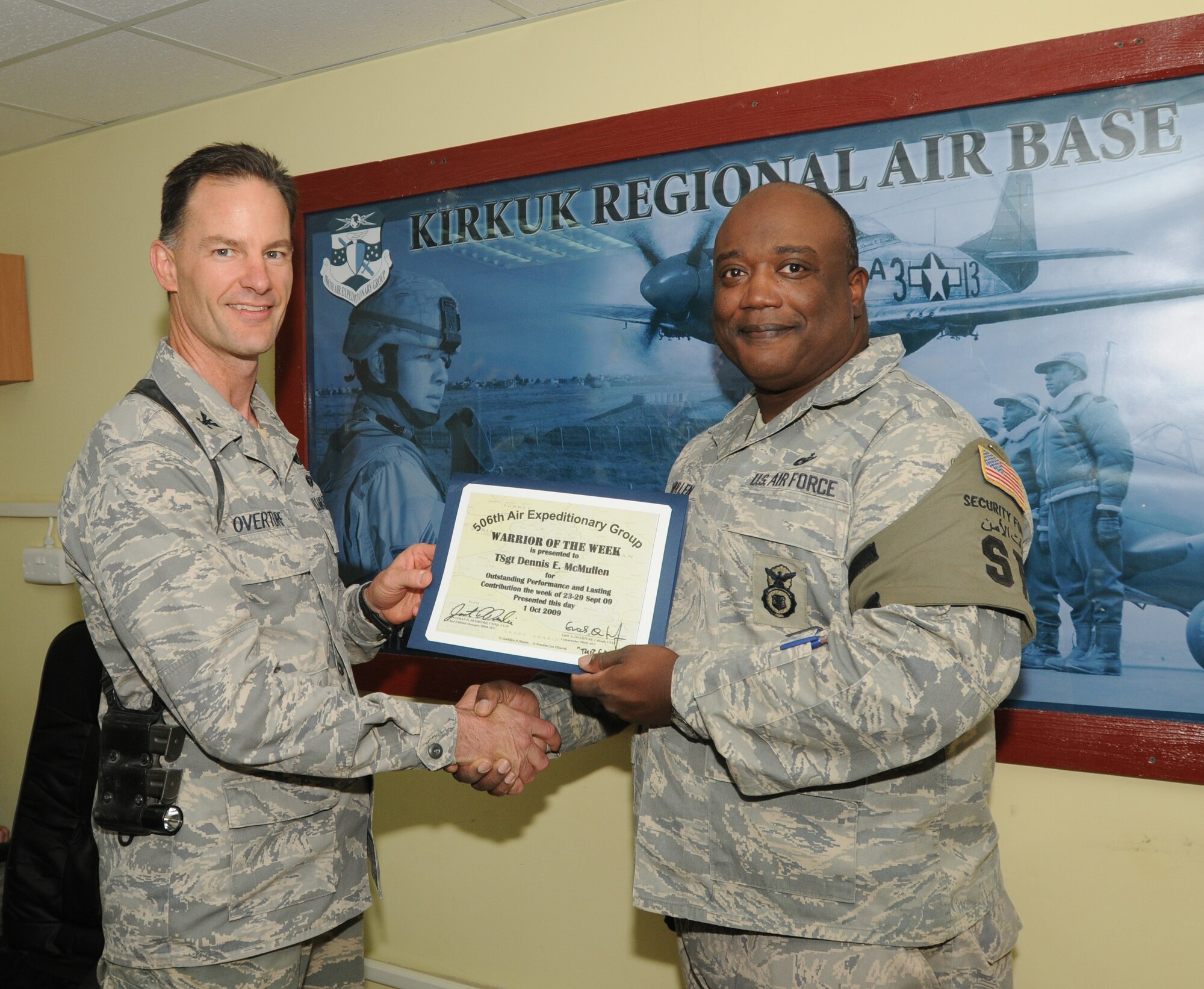 Technical Sergeant Dennis McMullen, a reservist assigned to the 315th Security Forces Squadron, Charleston AFB, S.C., receives the Warrior of the Week award while deployed to Kirkuk Regional Air Base, Iraq.  The recognition program highlights members who make significant contributions to their unit and base. He was presented the award by Colonel Eric Overturf, 506 AEG Commander. (Courtesy photo)