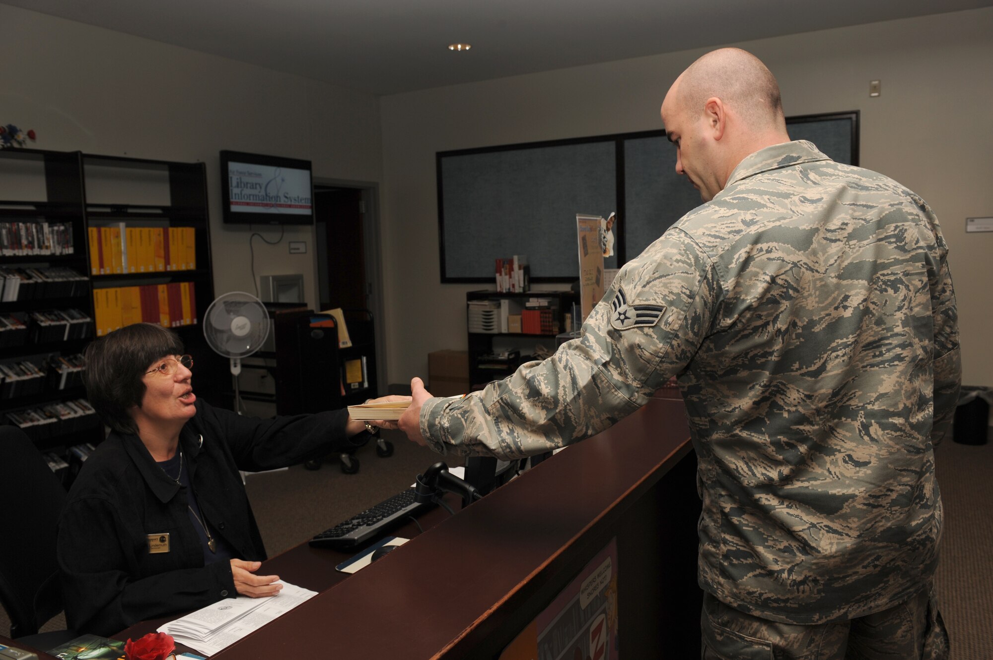 Phyllis Lindemath, 4th Force Support Squadron library technician, checks out a College-Level Examination Program book to Senior Airman John Aary, 4th Maintenance Operations Squadron, in the base library on Seymour Johnson Air Force Base, N.C., Sept. 23, 2009. The base library loans approximately 7,000 customers a month movies, books, or games. (U.S. Air Force photo by Airman 1st Class Whitney S. Lambert)