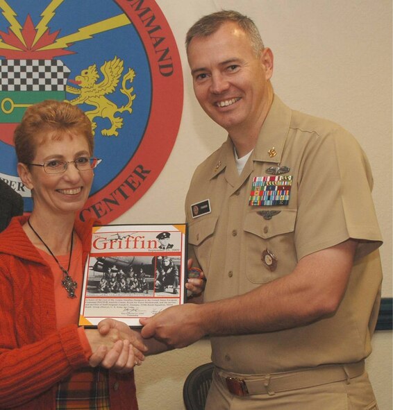 Ms. Louise Smedley-Hampson is presented a certificate by JIOCEUR Analytic Center Senior Enlisted Leader, Navy Master Chief John C. Frakes.  The certificate commemorates her visit and the service and sacrifice of Staff Sergeant Joseph G. "Zip: Zsampar, U.S. Army Air Corps to whom her mother, then Ms. Pauline "Bobby" Roberts was engaged before his B-17 Flying Fortress was shot down in May 1943. (U.S. Air Force Photo by Staff Sgt. Javier Cruz)