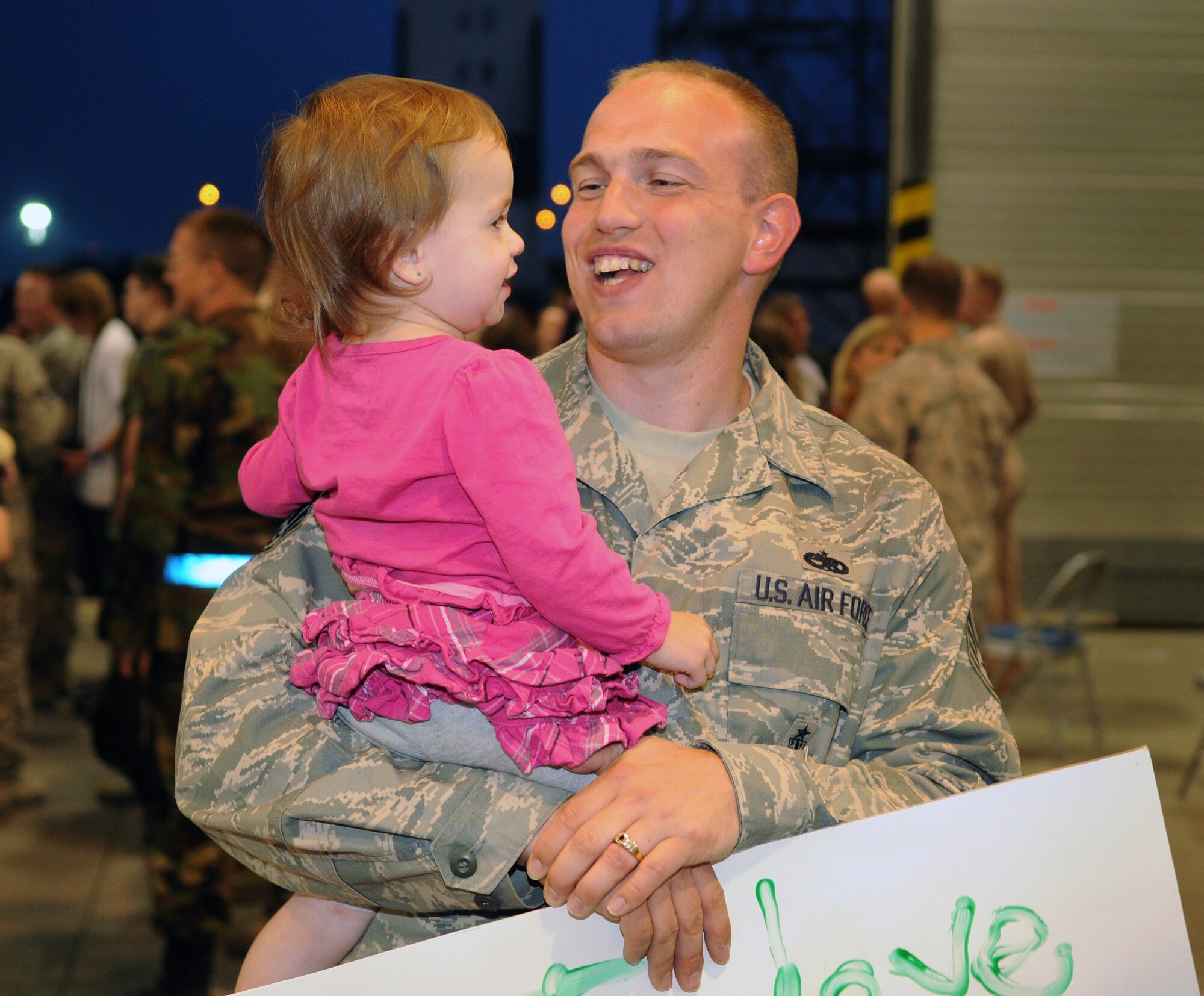 SPANGDAHLEM AIR BASE, Germany - Staff Sgt. Narley Wright, 52nd Equipment Maintenance Squadron, holds his daughter, Jasmine, at the 22nd Fighter Squadron redeployment party Sept. 28 at a hangar here. Sergeant Wright was deployed for four months to Joint Base Balad, Iraq, in direct support of the 22nd FS. During the deployment, the 22nd FS flew nearly 1,500 sorties and logged more than 6,000 hours of flight time in support of Operation Iraqi Freedom. (U.S. Air Force photo/Airman 1st Class Nathanael Callon)