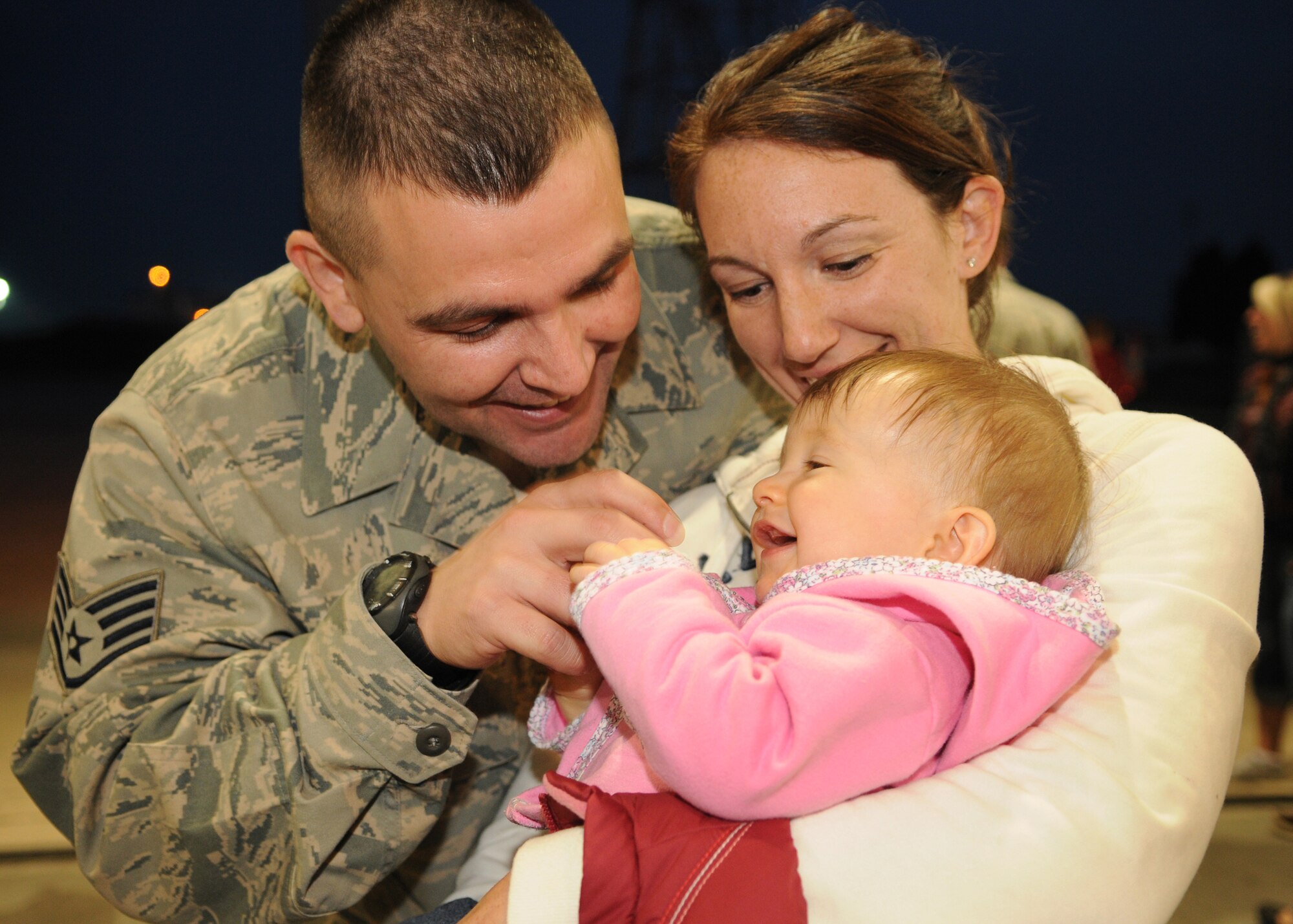 SPANGDAHLEM AIR BASE, Germany - Staff Sgt. Timothy Raso, 52nd Medical Operations Squadron, embraces his wife, Kristy, and daughter, Aaryanna, at the 22nd Fighter Squadron redeployment party Sept. 28 at a hanger her. Sergeant Raso provided medical support for the 22nd FS while deployed to Joint Base Balad, Iraq. During the four-month deployment, the 22nd FS flew nearly 1,500 sorties and logged more than 6,000 hours of flight time in support of Operation Iraqi Freedom. (U.S. Air Force photo/Airman 1st Class Nathanael Callon)