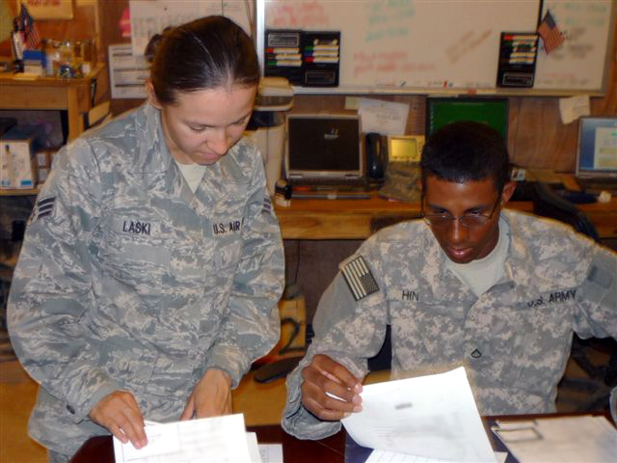 CAMP BUCCA, Iraq -- Senior Airman Angie Laski, 732nd Movement Control Team operations specialist and Pfc. Edwin Hines, 36th Sustainment Brigade liaison officer, verify trip tickets for cargo slated to depart Camp Bucca, Iraq, on the Basra sustainment convoy Sept. 27, 2009. Airman Laski is deployed from the 305th Aerial Port Squadron at McGuire Air Force Base, NJ. Pfc. Hines is deployed with the Texas Army National Guard from Temple, Texas. (U.S. Air Force photo/Senior Master Sgt. Jeff Criger)
