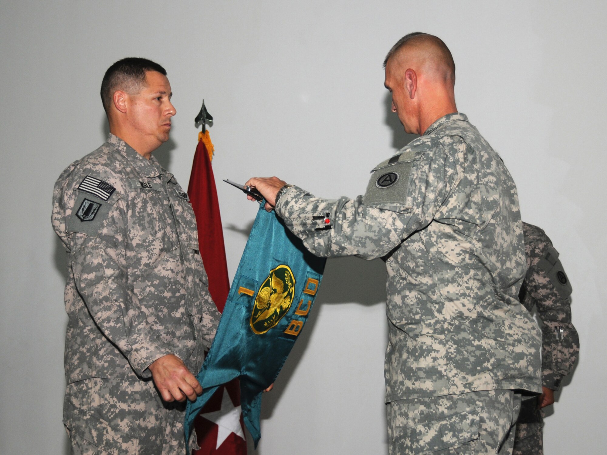 Col. Gary R. Hisle Jr., 1st Battlefield Coordination Detachment commander and Sgt. Maj. Thomas C. Reitmeier, 1 BCD sergeant major unfurl the unit guidon at a ceremony representing the unit's assumption of authority here, Sept. 27. The 1 BCD provides the required support for the integration of land and air operations in Southwest Asia while assigned to the Combined Air and Space Operations Center here. (U.S. Air Force Photo/Tech. Sgt. Jason W. Edwards)