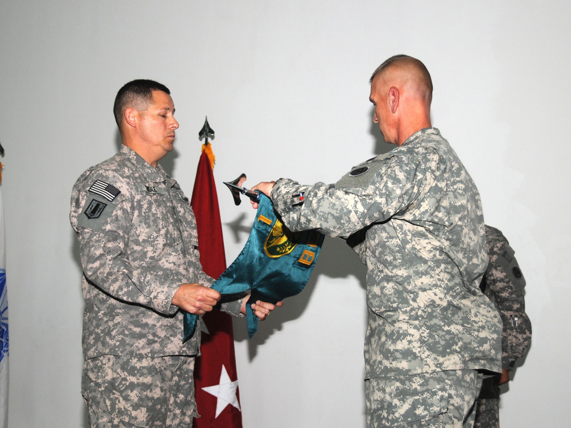 Col. Gary R. Hisle Jr., 1st Battlefield Coordination Detachment commander and Sgt. Maj. Thomas C. Reitmeier, 1 BCD sergeant major unfurl the unit guidon at a ceremony representing the unit's assumption of authority here, Sept. 27. The 1 BCD provides the required support for the integration of land and air operations in Southwest Asia while assigned to the Combined Air and Space Operations Center here. (U.S. Air Force Photo/Tech. Sgt. Jason W. Edwards)
