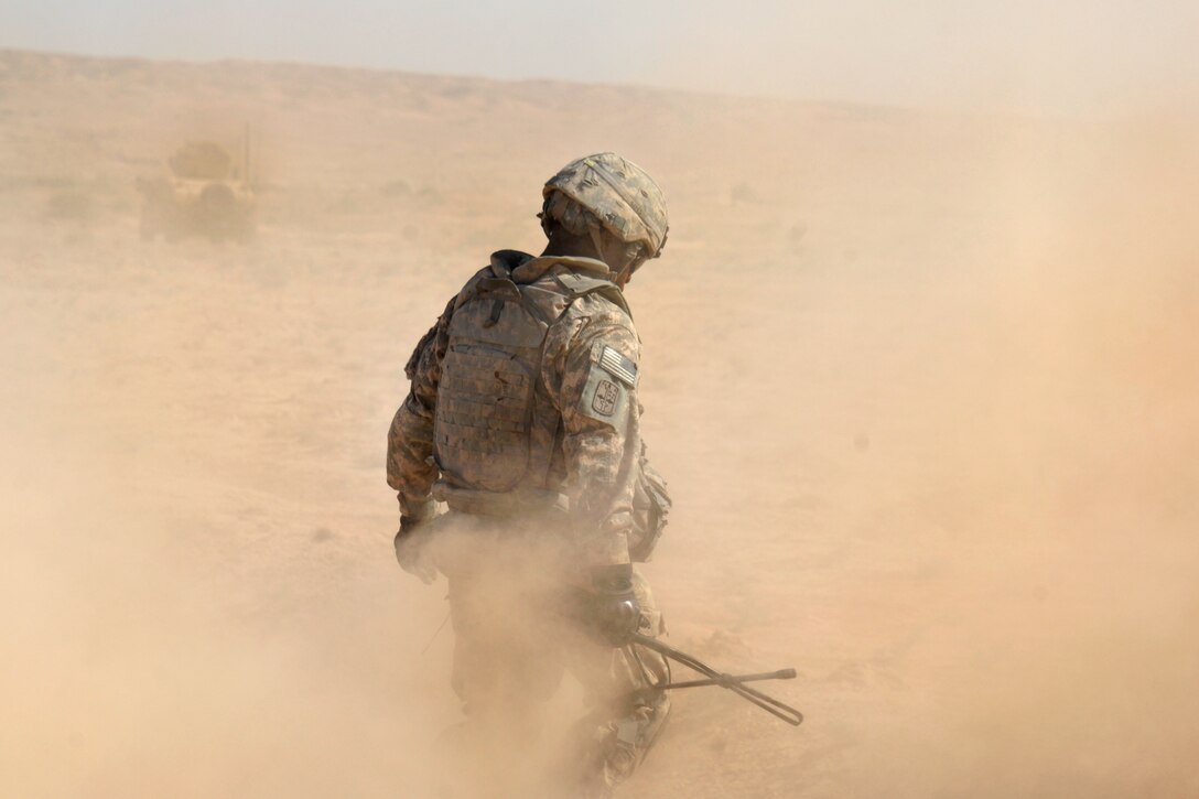 A U.S. Army soldier braves a cloud of dust during fording operations near the Iraq-Iran border, Iraq, Sept. 22, 2009. A bridge over a stream had been washed away by recent rains and the ford allows Military Transition Teams to conduct training with Iraqi border guards.