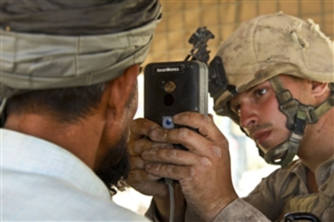 U.S. Marine Corps Lance Cpl. Brock Wilki, with 1st Battalion, 5th Marine Regiment, scans the iris of an Afghan man at an Afghan National Police checkpoint in the Nawa district of the Helmand province, Afghanistan, to register the man into a computer system database on Sept. 25, 2009.  Wilki is deployed with Regimental Combat Team 3 to conduct counterinsurgency operations in partnership with the Afghan National Security Forces in southern Afghanistan.  