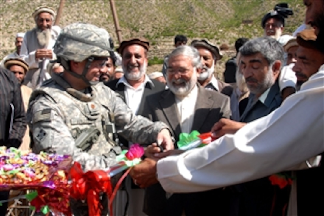 Kunar provincial governor Fazullah Wahidi, center, U.S. Navy Lt. Cmdr. Jay Burgess, Provincial Reconstruction Team-Kunar senior engineer, left, based at Camp Wright in Asadabad, Afghanistan, Brig. Gen. Khallullah Ziayee, Kunar Provincial chief of police, right, and village elders all took part in cutting the ribbon at a school in Loy Bachi, Afghanistan, Sept. 28, 2009. 