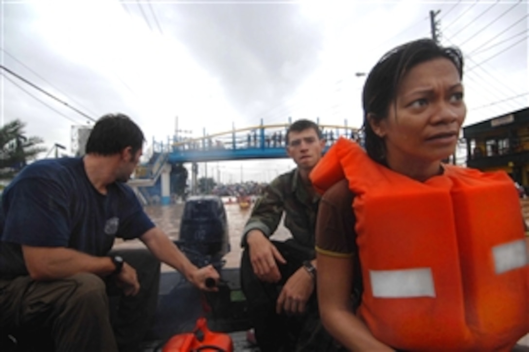 U.S. Navy sailors working with Joint Special Operations Task Force-Philippines rescue Manila residents after flooding destroyed homes and displaced thousands of people in Manila, Philippines, Sept. 27, 2009.  The sailors used two boats to assist more than 52 people, including a woman in labor, elderly residents and children.