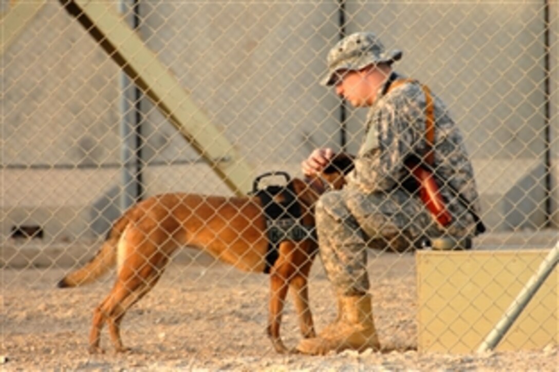 U.S. Air Force Staff Sgt. Justin Aycock spends a quiet moment alone with his military working dog Katya before training on Contingency Operating Base Adder, Dhi Qar, Iraq, Sept. 24, 2009. 
Aycock is assigned to the 52nd Security Forces Squadron, and provided demonstrations to the Iraqi Police on explosives searching techniques.