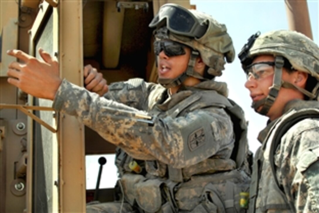 U.S. Army Spc. Andrew Beeson, right, and Pfc. Nicolas Blazak discuss the best way to repair a road damaged by rains near the Iraq-Iran border, Sept. 23, 2009. Beeson and Blazak are assigned to Company C, 9th Engineer Battalion.