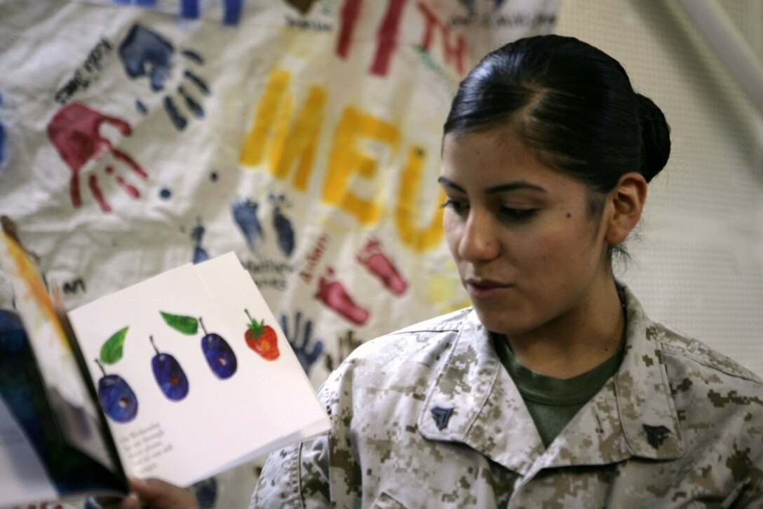 Cpl. Martha V. Estevane reads a children’s book for her daughter in Texas while being video taped on board USS Bonhomme Richard Sept. 28. The recording will be sent to Estevane’s child as part of United Through Reading, a program intended to keep deployed parents connected with their children through videotaped reading sessions.