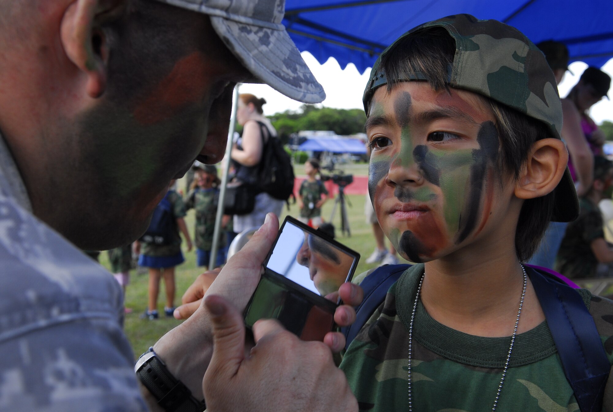 Ian Tateishi gets his “war paint” applied during Skoshi Warrior2009. Nearly 200 children participated in the 4-hour condensed "fun" version of a deployment at Marek Park on Sept 26.   

(U.S. Air Force photo / Tech. Sgt. Mike Tateishi)