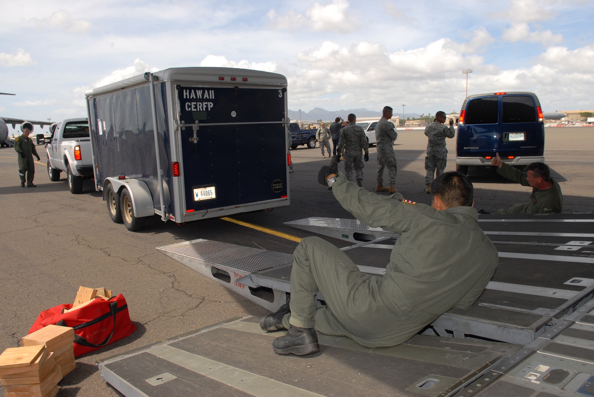 Airmen from the 204th Airlift Wing, Hawaii Air National Guard, load a vehicle onto a C-17 Globemaster III Sept. 30 at Hickam Air Force Base, Hawaii, in preparation for departure for Operation Pacific Wave, a humanitarian mission in Amercian Samoa. The island nation was devastated by an earthquake and Tsunami Sept. 29. (U.S. Air Force photo/Tech. Sgt. Jerome Tayborn)