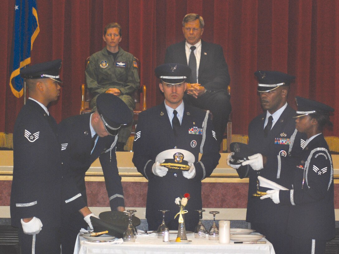 Members of the honor guard each represent a different branch of service as they place covers on the table during the POW/MIA Service Sep. 18. (U.S. Air Force photo by Megan Just)