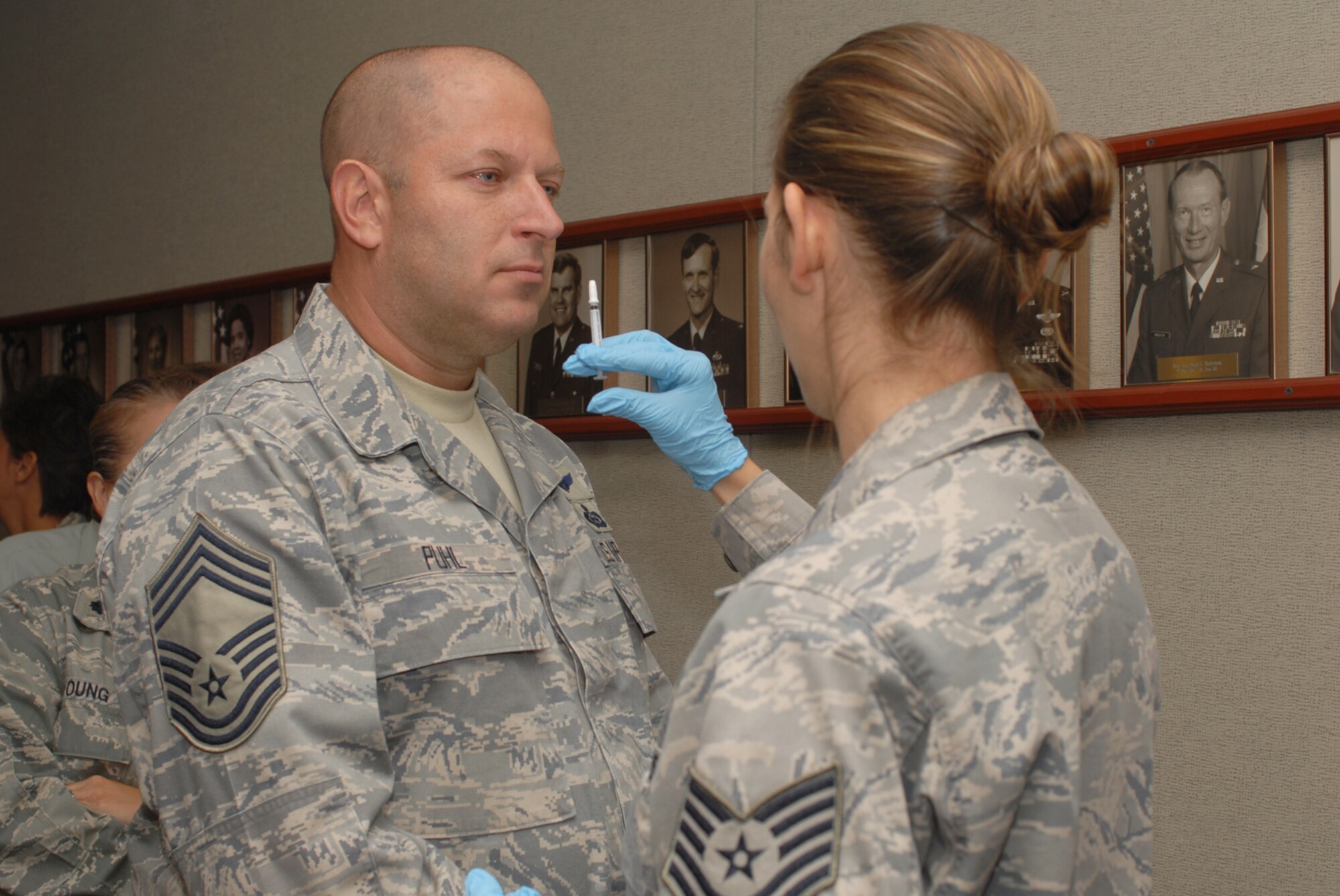 GOODFELLOW AIR FORCE BASE, Texas -- Chief Master Sgt. Robert Puhl, 17th Training Group chief enlisted manager, receives the FluMist from Tech Sgt. Nicole Melius, 17th Medical Group, Sept. 29, 2009. The FluMist is a live, but weakened, influenza virus that is sprayed into the nostrils as opposed to the flu shot, a dead virus, that is injected into the muscle. (U.S. Air Force photo/Staff Sgt. Laura R. McFarlane)