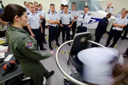 1st Lt. Amanda Burnette, left, an aerospace physiologist with the 12th Medical Group at Randolph Air Force Base, Texas spins a combast system's officer student in the Barany Chair to induce the Coriolis illusion, in an effort to familiarize the class with the effects of motion on the inner ear. This training teaches them not to trust what they feel, but to rely on their instruments. (U.S. Air Force photo/Steve Thurow)