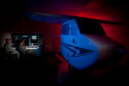 Senior Airman Jason Boyd, left, and Staff Sgt. Vikas Kumar aerospace physiology technicians with the 12th Medical Group at Randolph Air Force Base, Texas monitor a trainee during a night instrument training in the GAT II, General Aviation Trainer, spatial disorientation and flight trainer which are used to familiarize aviators with the effects of spatial disorientation and the importance of trusting their instruments and not how they feel. (U.S. Air Force photo/Steve Thurow)