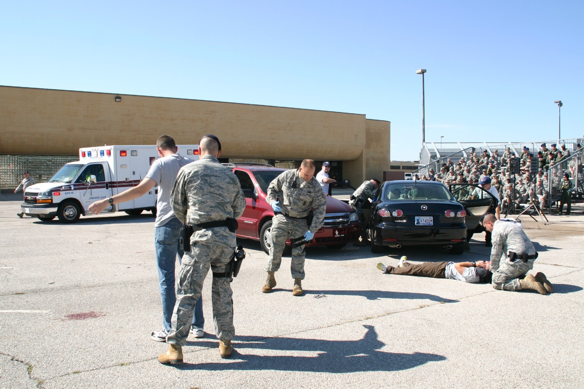 TINKER AFB, Okla. -- Members of the 552nd Air Control Wing observe as Security Forces Airmen and emergency medical personnel respond to a staged drunk driving accident on base.  As part of the 552nd Air Control Wing’s Safety Day, the Junior Enlisted Council sponsored an enactment of a DUI car accident to help members of the wing internalize the grave consequences of driving under the influence. US Air Force Photo / 1st Lt. Kinder Blacke.