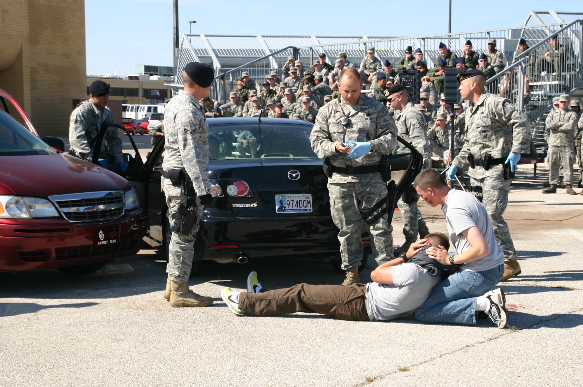 TINKER AFB, Okla. -- Members of the 552nd Air Control Wing observe as Security Forces Airmen and emergency medical personnel respond to a staged drunk driving accident on base.  As part of the 552nd Air Control Wing’s Safety Day, the Junior Enlisted Council sponsored an enactment of a DUI car accident to help members of the wing internalize the grave consequences of driving under the influence. US Air Force Photo / 1st Lt. Kinder Blacke.