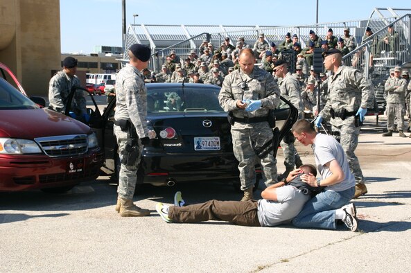 TINKER AFB, Okla. -- Members of the 552nd Air Control Wing observe as Security Forces Airmen and emergency medical personnel respond to a staged drunk driving accident on base.  As part of the 552nd Air Control Wing’s Safety Day, the Junior Enlisted Council sponsored an enactment of a DUI car accident to help members of the wing internalize the grave consequences of driving under the influence. US Air Force Photo / 1st Lt. Kinder Blacke.