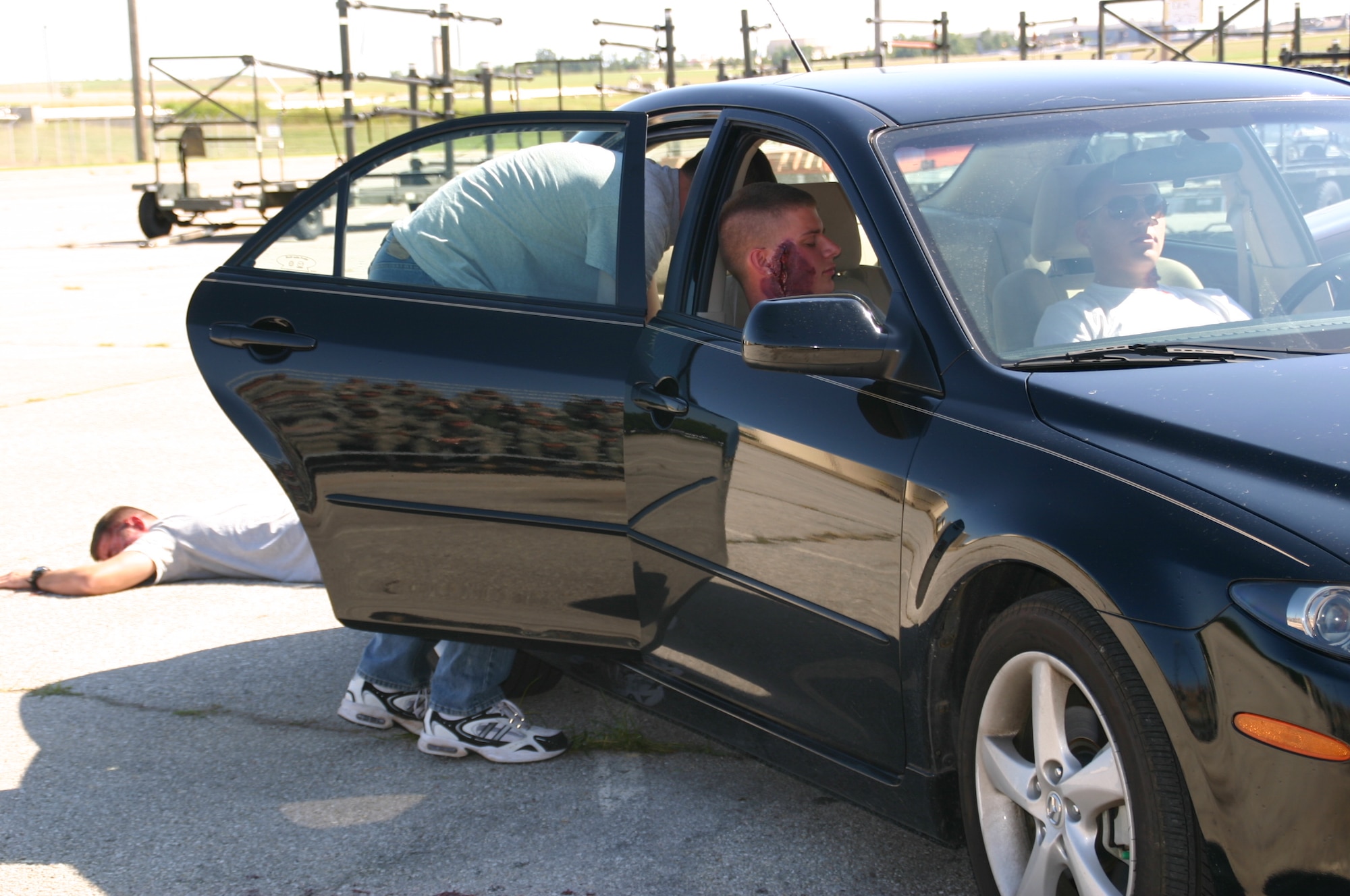 TINKER AFB, Okla. -- Members of the 552nd Air Control Wing observe as Security Forces Airmen and emergency medical personnel respond to a staged drunk driving accident on base.  As part of the 552nd Air Control Wing’s Safety Day, the Junior Enlisted Council sponsored an enactment of a DUI car accident to help members of the wing internalize the grave consequences of driving under the influence. US Air Force Photo / 1st Lt. Kinder Blacke.