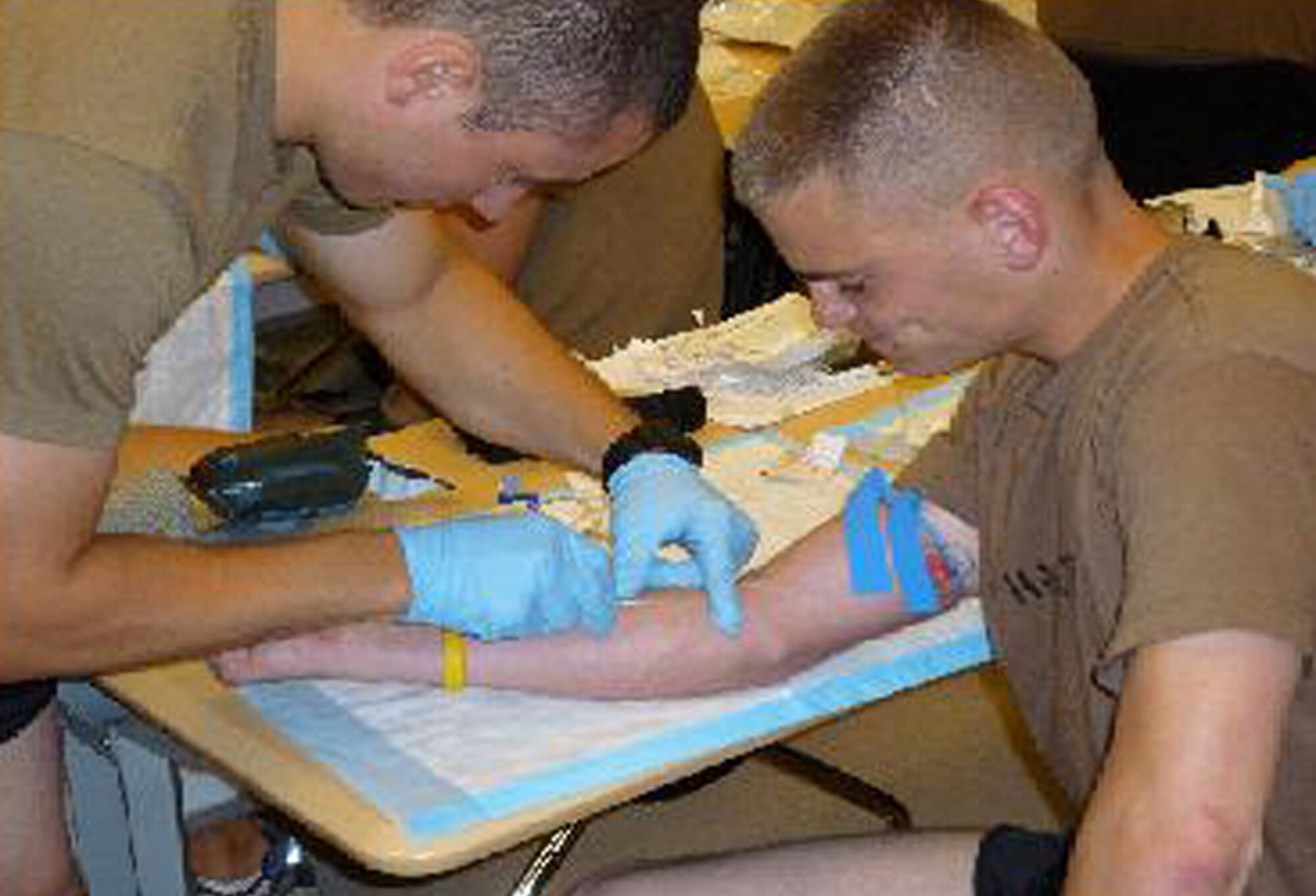 Cadet Ian Kemp from Norwich University's Air Force ROTC Detachment 867 practices giving an IV to fellow Cadet Justin Hazlett as part of the special operations tactics orientation program at Hurlburt Field, Fla. During the program, cadets received classroom and hands-on instruction on how to perform and connect IVs. (U.S. Air Force photo/Maj. Jeff Cooper)