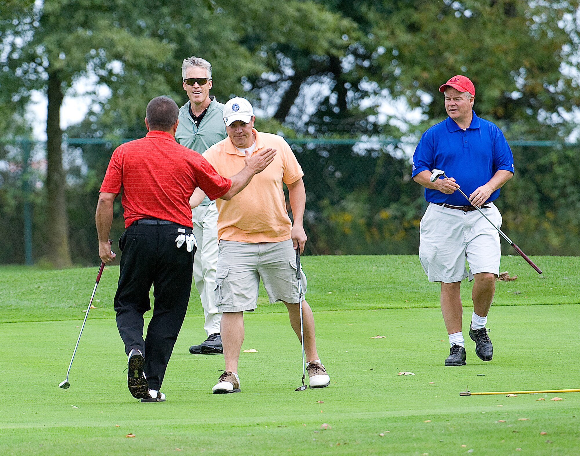 (From left) Steve Hoffstadt high fives Maj. Cory Bulris after a successful putt, while Dave Clapp and Col. Dave Hafer look on during the Bluesuiter's golf tournament Sept. 29. The foursome of Colonel Hafer, Mr. Clapp, Major Bulris and Mr. Hoffstadt took first place in the tournament with a score of 57. (U.S. Air Force photo by Jason Minto)