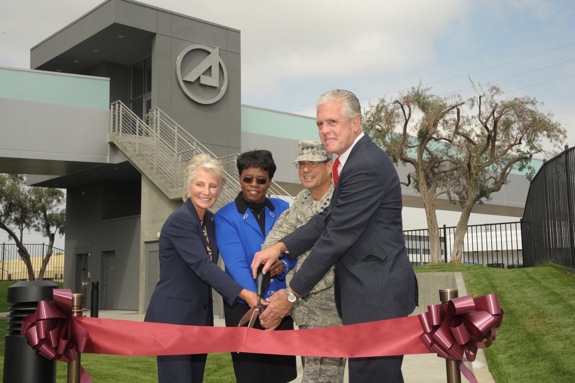 From left to right, Congresswoman Jane Harmon, Aerospace Corporation CEO Dr. Wanda Austin, SMC Commander Lt. Gen. Tom Sheridan and El Segundo Mayor Kelly McDowell cut the ribbon to officially open the new pedestrian bridge linking Los Angeles Air Force Base and The Aerospace Corporation facilities, Sept. 29. (Photo by Lou Hernandez)