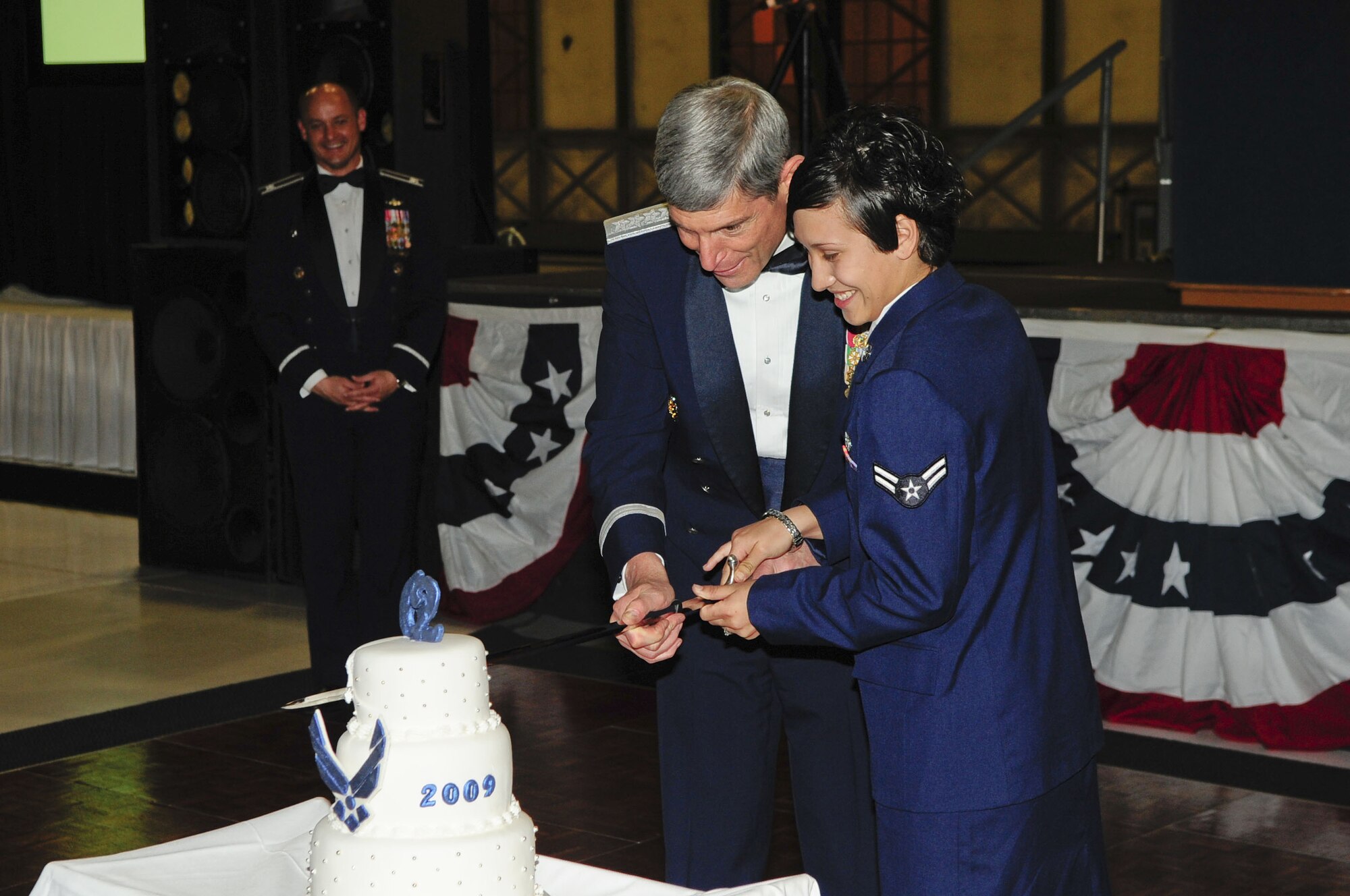 Col Kevin Kilb, 62nd Airlift Wing commander, looks on as Air Force Chief of Staff Gen. Norton Schwartz and Airman 1st Class Rebecca Arnold slice the Air Force Birthday cake with a saber at McChord's 62nd Air Force Birthday celebration, Sept 26. (U.S. Air Force photo by Master Sgt. Chris Haylett)