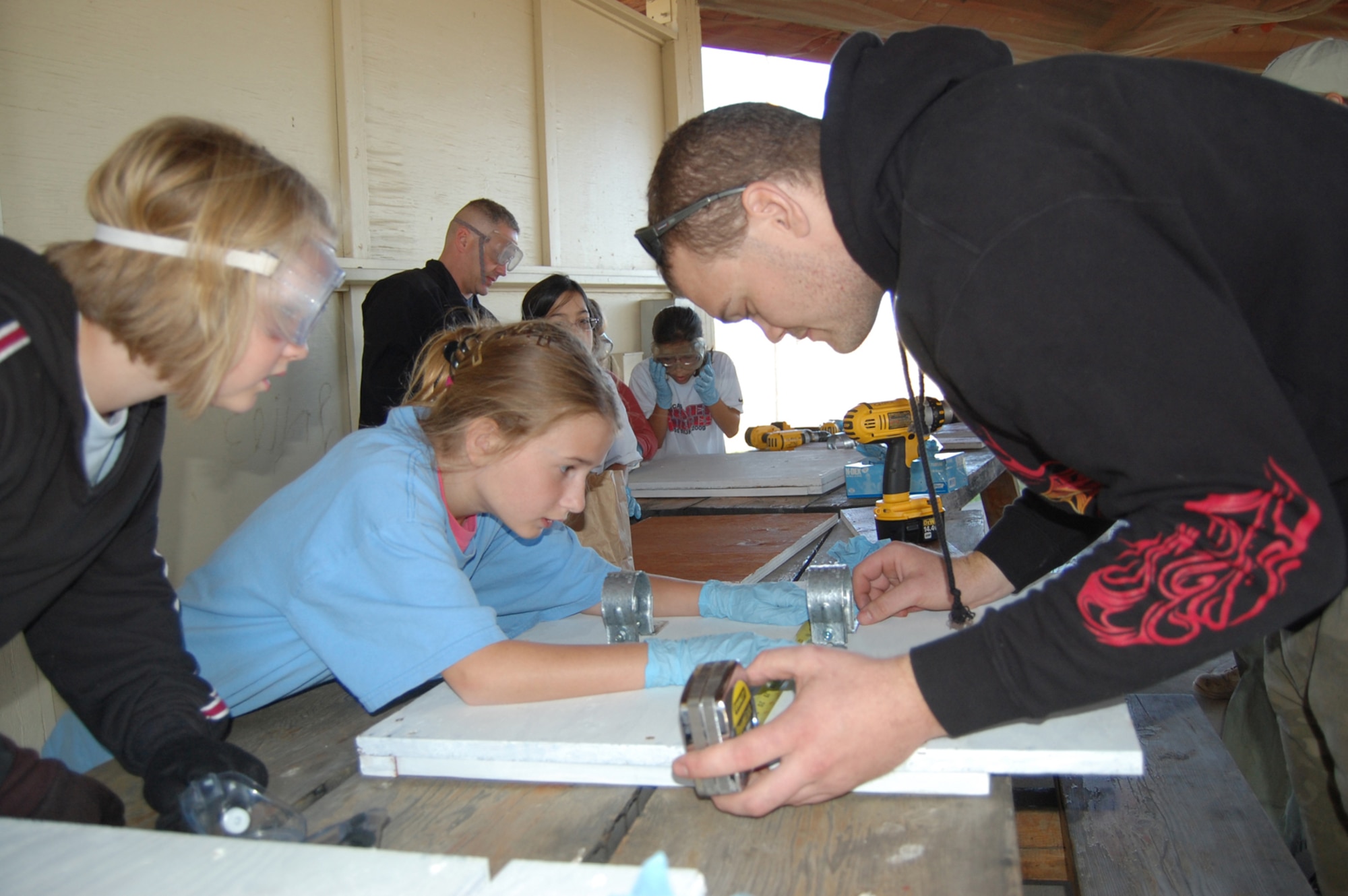 Girl Scout Samantha Moad, 11, helps Staff Sgt. Chris Daniels, 341st Maintenance Operations Squadron, measure for center on a bat house they were constructing Sept. 26 for a National Public Lands Day project. Fellow Scout Kelsey Penny, 10, looks on. (U.S. Air Force photo/Valerie Mullett)