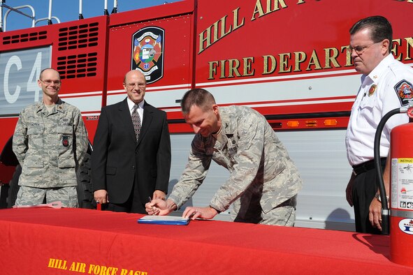 Col. Patrick Higby, 75th Air Base Wing commander, signs an official proclamation declaring Oct. 4-10 to be Fire Prevention Week as Maj. James Palmer (left to right), commander of the 775th Civil Engineering Squadron; Buddy Briesmaster, 75th Civil Engineering Group director; and 775th CES Fire Chief Paul Erickson watch. Events will be planned throughout the week, including honorary firemen for the day, essay contests and static displays. (USAF Photo by Alex R. Lloyd)